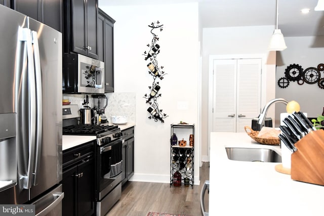 10401 Resort Rd Unit F, Ellicott City, MD 21042 - kitchen featuring appliances with stainless steel finishes, a sink, light countertops, wood finished floors, and dark cabinets