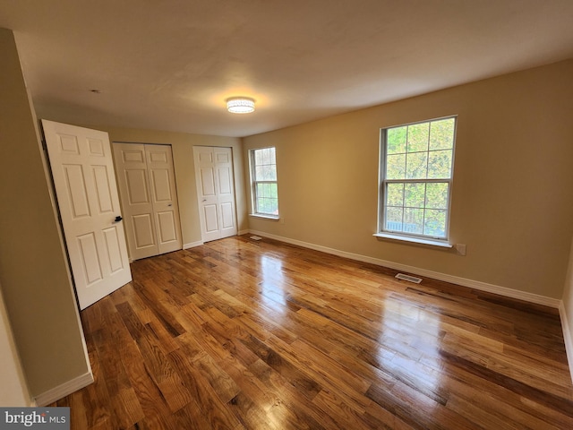 7331 Branchwood Ter, Clinton, MD 20735 - unfurnished bedroom with multiple closets, wood finished floors, and baseboards