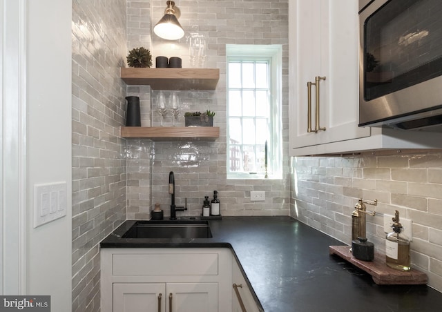 1901 Wyoming Ave NW Unit 40, Washington, DC 20009 - kitchen featuring stainless steel microwave, a sink, decorative backsplash, and dark countertops