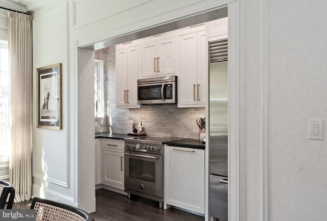 1901 Wyoming Ave NW Unit 40, Washington, DC 20009 - kitchen with high quality appliances, dark countertops, decorative backsplash, dark wood finished floors, and white cabinets