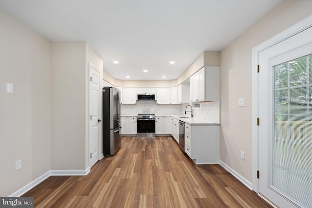 22 Buck Rd, Stafford, VA 22556 - kitchen featuring appliances with stainless steel finishes, a sink, dark wood-style floors, ventilation hood, and decorative backsplash