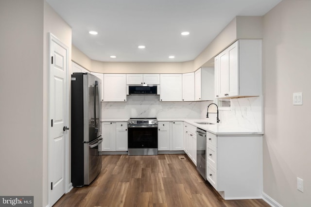 22 Buck Rd, Stafford, VA 22556 - kitchen with appliances with stainless steel finishes, a sink, dark wood finished floors, backsplash, and white cabinets