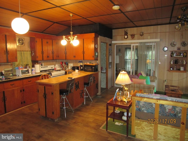 410 Pine Glen Rd, Moshannon, PA 16859 - kitchen with black microwave, white gas range, dark wood-style floors, brown cabinetry, and wooden walls