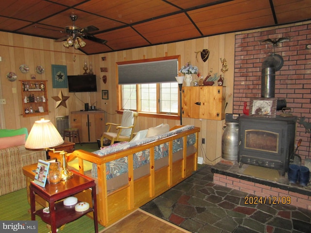 410 Pine Glen Rd, Moshannon, PA 16859 - living room featuring a ceiling fan, a wood stove, and wood walls
