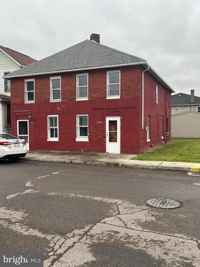 209 Blocker St, Ridgeley, WV 26753 - view of home's exterior featuring a chimney, brick siding, and roof with shingles