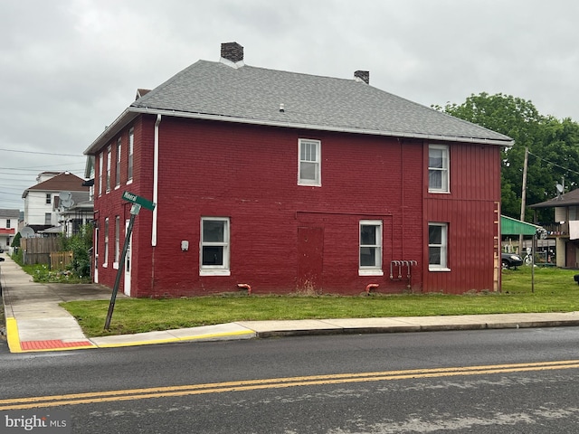 209 Blocker St, Ridgeley, WV 26753 - view of property exterior featuring brick siding, a chimney, a yard, and a shingled roof