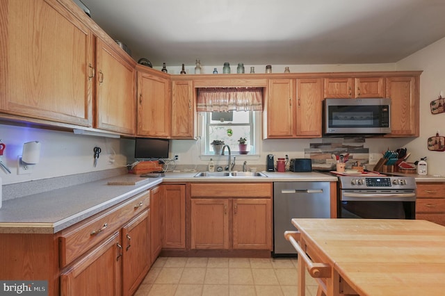 24519 Cedar Ln, Georgetown, DE 19947 - kitchen with appliances with stainless steel finishes, a sink, light countertops, and brown cabinetry