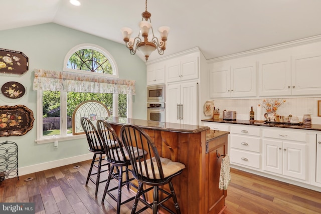 2538 Church Ln, Doylestown, PA 18902 - kitchen with stainless steel appliances, vaulted ceiling, a kitchen island, a breakfast bar area, and white cabinets