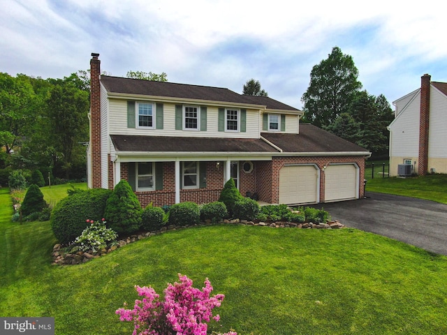 10 Eastbrooke Dr, Ephrata, PA 17522 - view of front of house featuring a chimney, asphalt driveway, a garage, cooling unit, and a front lawn