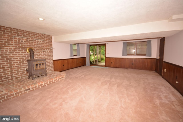 10 Eastbrooke Dr, Ephrata, PA 17522 - unfurnished living room with wainscoting, a wood stove, wooden walls, and carpet floors