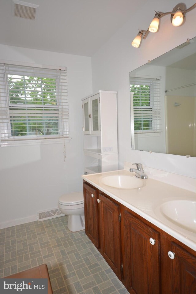 10 Eastbrooke Dr, Ephrata, PA 17522 - bathroom with double vanity, toilet, baseboards, and a shower