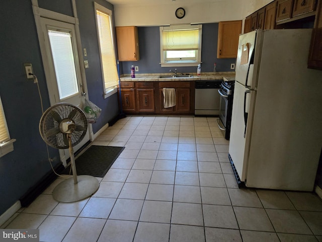1151 E King St, York, PA 17403 - kitchen with stainless steel appliances, tile counters, a sink, light tile patterned flooring, and baseboards