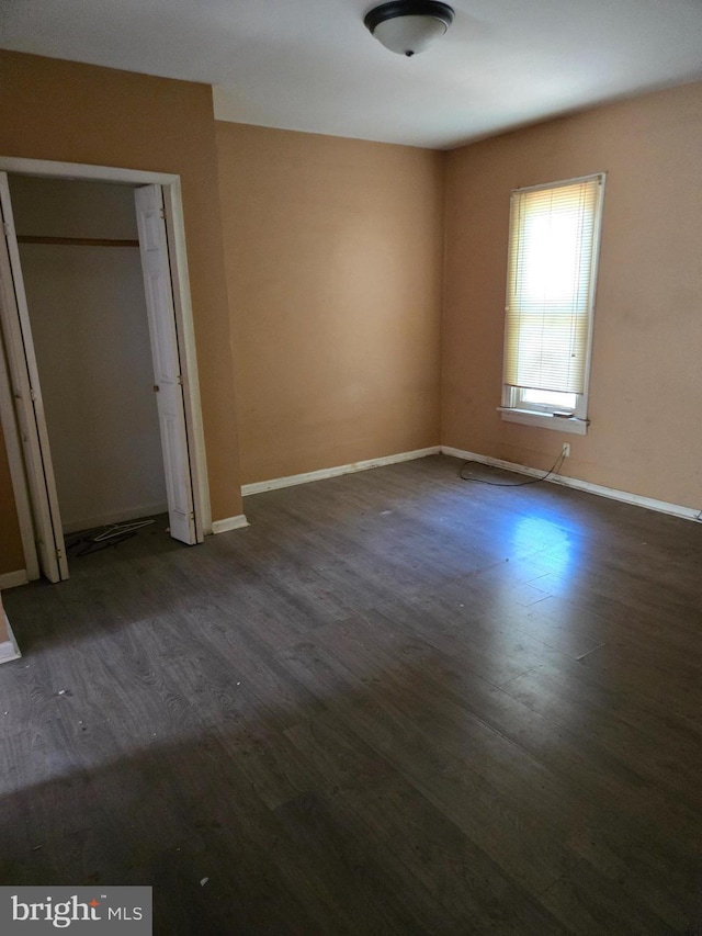 1151 E King St, York, PA 17403 - unfurnished bedroom with dark wood finished floors, baseboards, and a closet