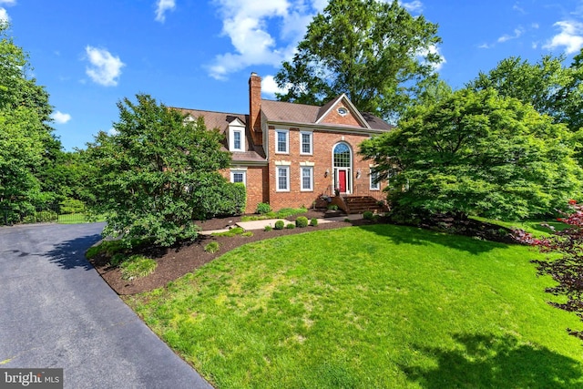 2200 Traies Ct, Alexandria, VA 22306 - colonial home featuring a chimney, a front yard, brick siding, and driveway