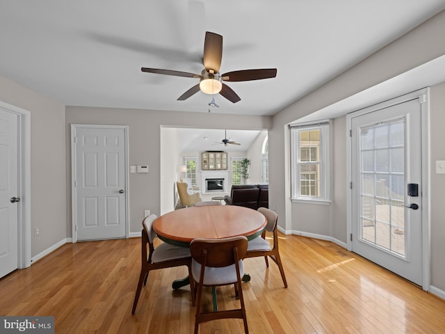 2200 Traies Ct, Alexandria, VA 22306 - dining space with a glass covered fireplace, a ceiling fan, light wood finished floors, and baseboards
