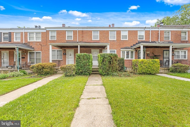 5649 Kavon Ave, Baltimore, MD 21206 - townhome / multi-family property featuring brick siding, a front yard, and covered porch