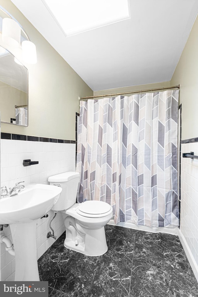 5649 Kavon Ave, Baltimore, MD 21206 - bathroom with tile walls, toilet, wainscoting, marble finish flooring, and a shower with shower curtain