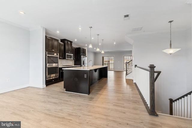 14438 Mattawoman Dr Unit 5000H, Brandywine, MD 20613 - kitchen with stainless steel appliances, ornamental molding, light countertops, an island with sink, and baseboards