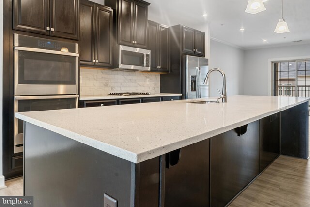 14438 Mattawoman Dr Unit 5000H, Brandywine, MD 20613 - kitchen with stainless steel appliances, a spacious island, tasteful backsplash, crown molding, and light wood-type flooring