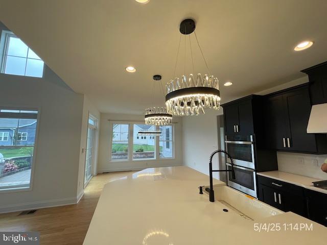 31123 Surfbird Way, Millsboro, DE 19966 - kitchen featuring dark cabinetry, a chandelier, light countertops, recessed lighting, and pendant lighting