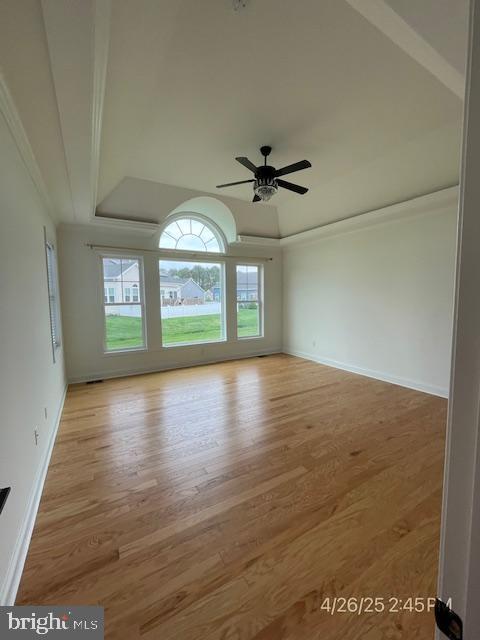 31123 Surfbird Way, Millsboro, DE 19966 - empty room featuring wood finished floors, baseboards, a raised ceiling, and crown molding