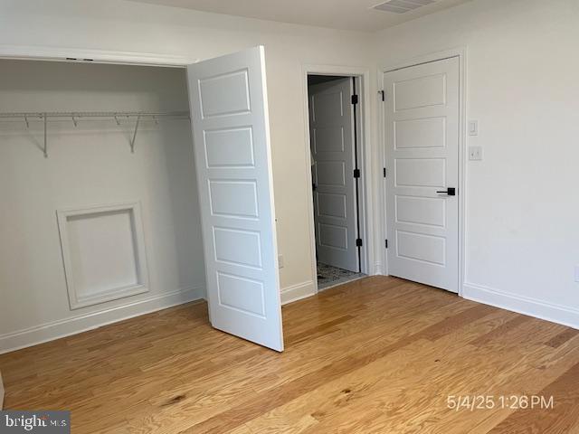 31123 Surfbird Way, Millsboro, DE 19966 - unfurnished bedroom featuring a closet, baseboards, and light wood-style floors