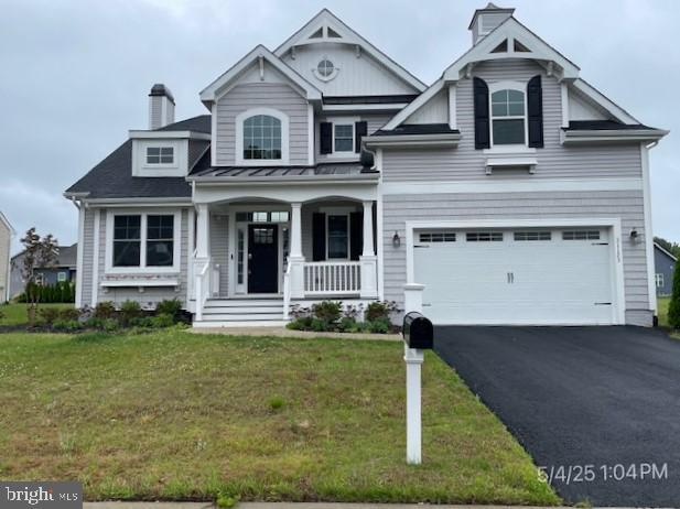 31123 Surfbird Way, Millsboro, DE 19966 - view of front of house with covered porch, a garage, a chimney, asphalt driveway, and a front yard
