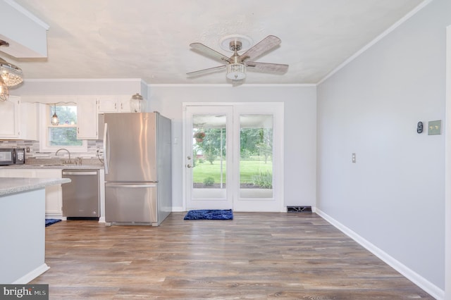 1267 Dominion Rd, Gerrardstown, WV 25420 - kitchen with appliances with stainless steel finishes, ceiling fan, white cabinets, wood finished floors, and crown molding