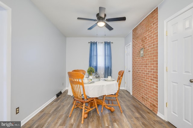 1267 Dominion Rd, Gerrardstown, WV 25420 - dining space featuring wood finished floors, a ceiling fan, baseboards, and brick wall