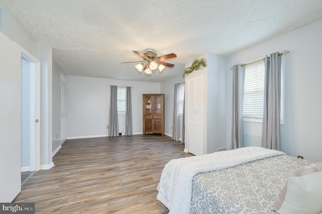 1267 Dominion Rd, Gerrardstown, WV 25420 - bedroom featuring a textured ceiling, wood finished floors, a closet, ceiling fan, and baseboards