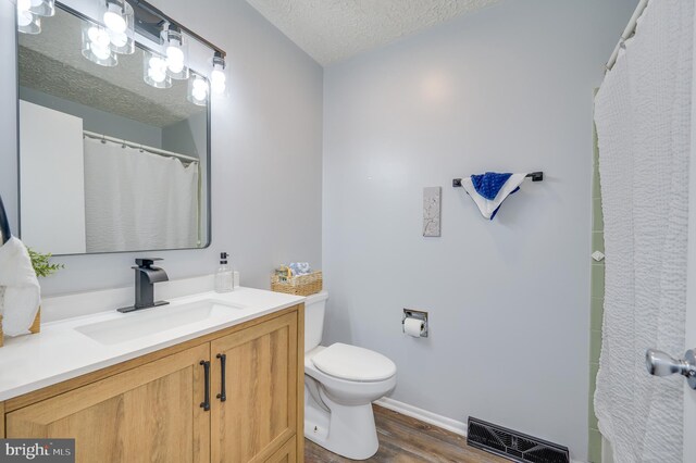 1267 Dominion Rd, Gerrardstown, WV 25420 - full bathroom with toilet, wood finished floors, vanity, a textured ceiling, and baseboards