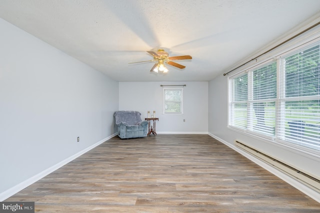 1267 Dominion Rd, Gerrardstown, WV 25420 - unfurnished room featuring a baseboard radiator, ceiling fan, baseboards, and wood finished floors