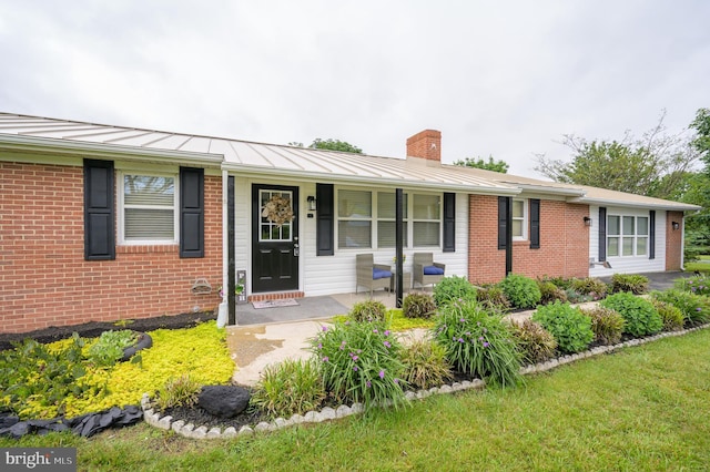 1267 Dominion Rd, Gerrardstown, WV 25420 - ranch-style house featuring a chimney, a standing seam roof, a porch, brick siding, and metal roof
