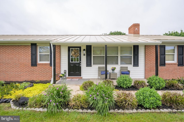 1267 Dominion Rd, Gerrardstown, WV 25420 - ranch-style home featuring a standing seam roof, a porch, a chimney, and brick siding