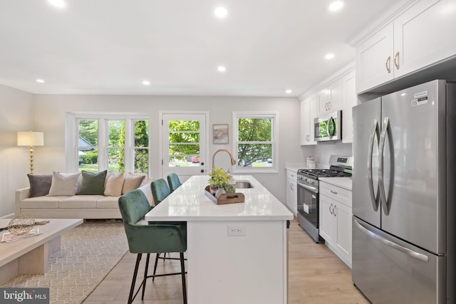 112 Morris Ave, Woodlyn, PA 19094 - kitchen with stainless steel appliances, a sink, a breakfast bar area, white cabinets, and recessed lighting