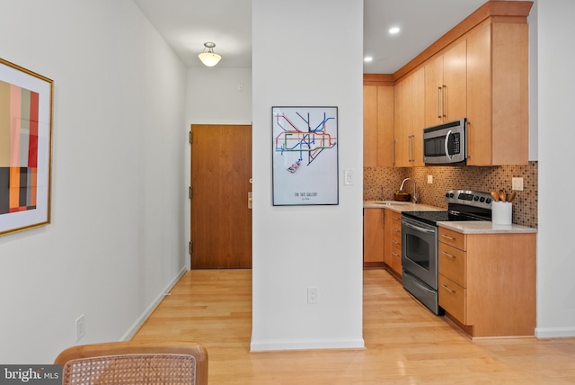 1615 Q St NW Unit 214, Washington, DC 20009 - kitchen with appliances with stainless steel finishes, light countertops, light wood-style flooring, backsplash, and recessed lighting