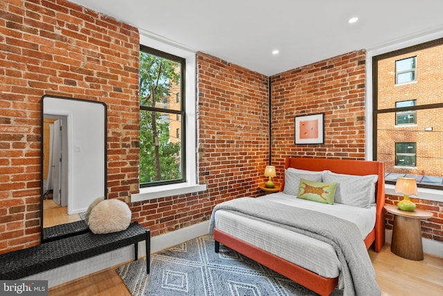 1615 Q St NW Unit 214, Washington, DC 20009 - bedroom featuring wood finished floors, brick wall, and recessed lighting