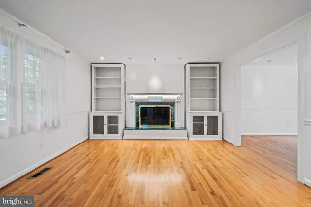 530 Anneslie Rd, Baltimore, MD 21212 - unfurnished living room featuring crown molding, hardwood / wood-style floors, a fireplace, baseboards, and built in shelves