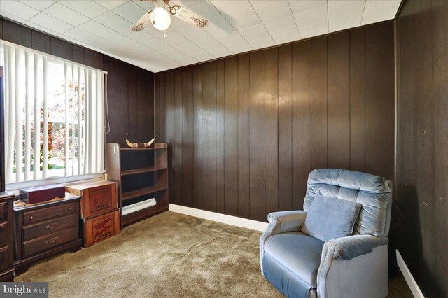 1807 King St, Reading, PA 19605 - living area with wood walls, light colored carpet, ceiling fan, and baseboards