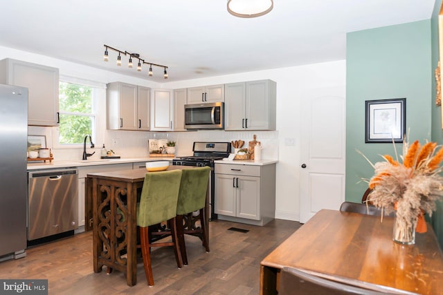 3302 Orlando Ave, Baltimore, MD 21234 - kitchen featuring appliances with stainless steel finishes, gray cabinetry, dark wood-style floors, and decorative backsplash