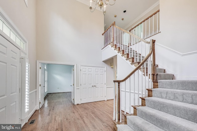 10106 Waterside Dr, Burke, VA 22015 - entrance foyer featuring a towering ceiling, stairway, a chandelier, wood finished floors, and plenty of natural light