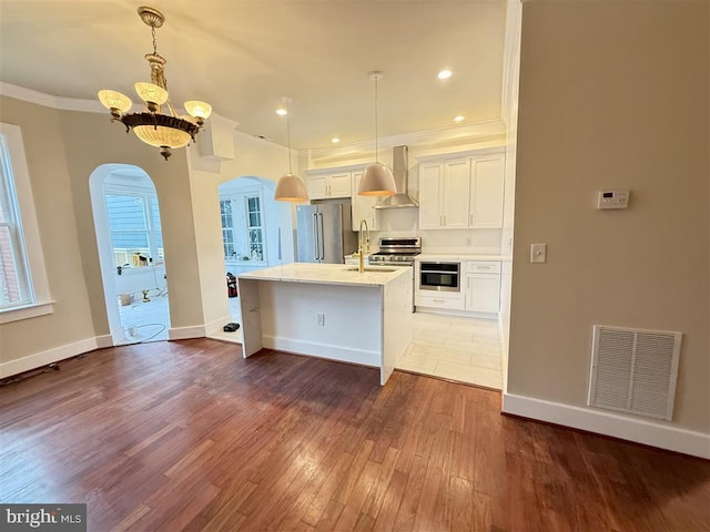 40 Bryant St NW, Washington, DC 20001 - kitchen featuring appliances with stainless steel finishes, arched walkways, wall chimney range hood, a sink, and crown molding