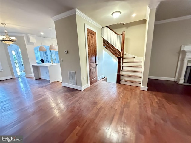 40 Bryant St NW, Washington, DC 20001 - unfurnished living room featuring crown molding, stairway, wood finished floors, arched walkways, and baseboards