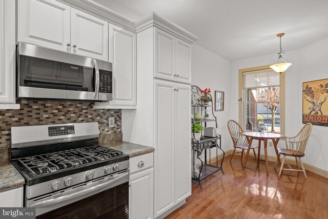 66 Farmview Ln, Lititz, PA 17543 - kitchen with appliances with stainless steel finishes, light wood-style flooring, decorative backsplash, white cabinets, and baseboards