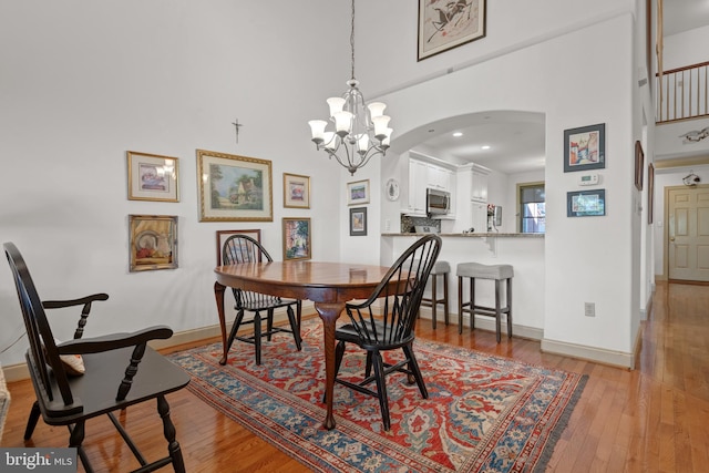 66 Farmview Ln, Lititz, PA 17543 - dining area featuring arched walkways, a towering ceiling, wood-type flooring, a chandelier, and baseboards