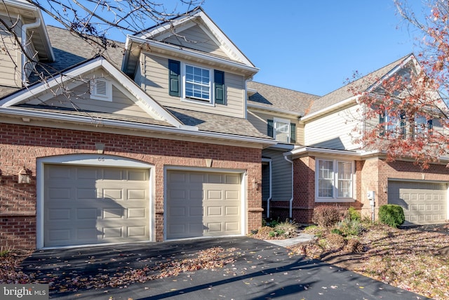 66 Farmview Ln, Lititz, PA 17543 - view of front facade featuring brick siding, a garage, driveway, and roof with shingles