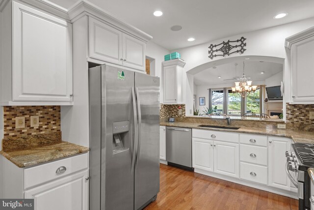 66 Farmview Ln, Lititz, PA 17543 - kitchen featuring appliances with stainless steel finishes, a chandelier, arched walkways, a sink, and decorative backsplash