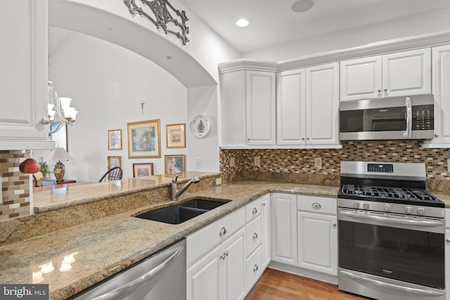 66 Farmview Ln, Lititz, PA 17543 - kitchen featuring stainless steel appliances, a sink, light stone countertops, and white cabinetry