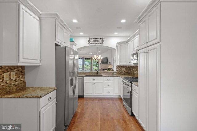 66 Farmview Ln, Lititz, PA 17543 - kitchen featuring stainless steel appliances, arched walkways, white cabinets, light wood-style floors, and recessed lighting