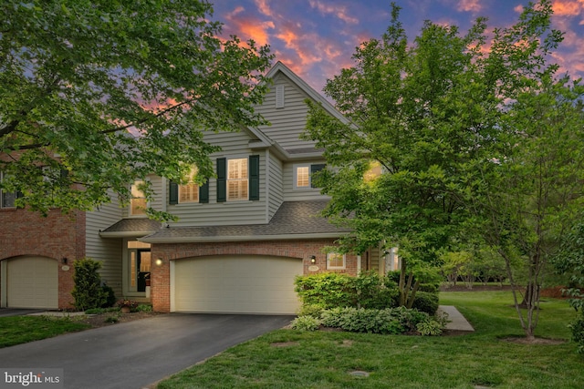 285 Cherry Ln, Kennett Square, PA 19348 - view of front of home with driveway, an attached garage, brick siding, a lawn, and roof with shingles